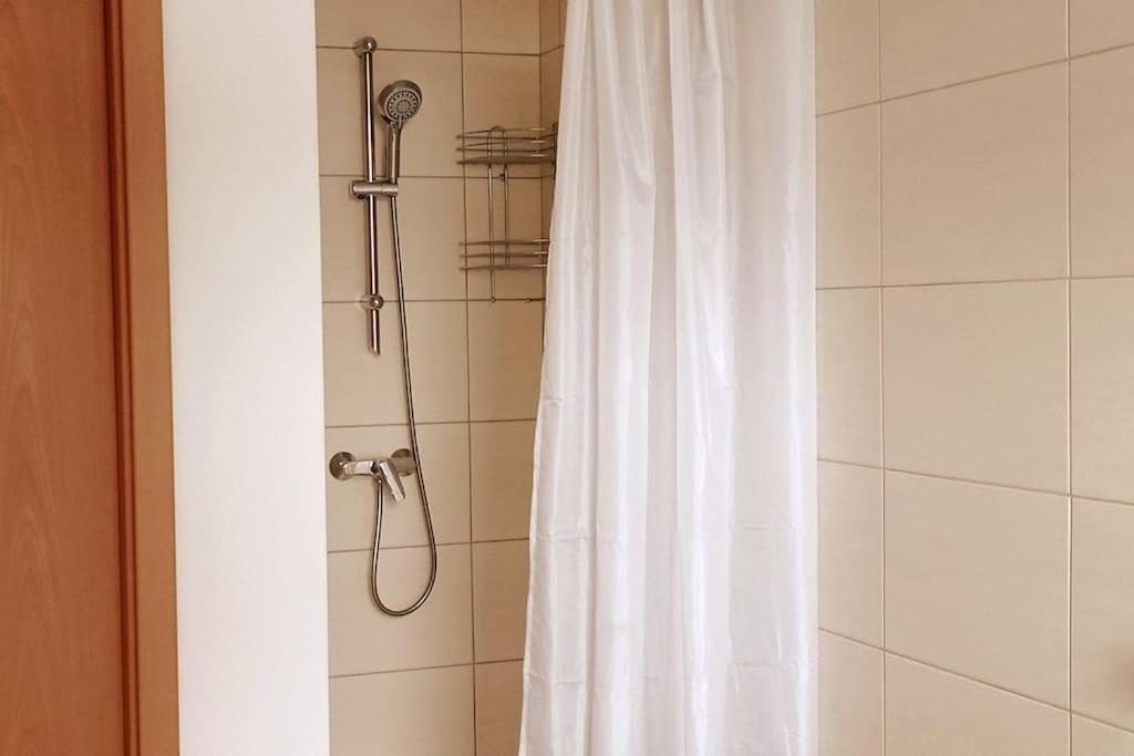 a shower with a white shower curtain in a bathroom at Jugendstilvilla voll renoviert in Falkenstein
