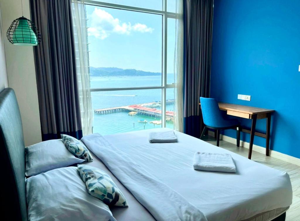 1 dormitorio con ventana grande, cama y escritorio en Seaview Mercure Hotel Suite KK City Center, en Kota Kinabalu