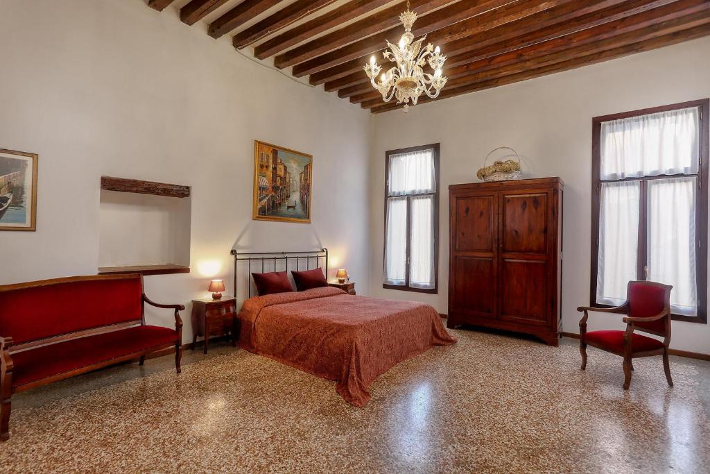 a bedroom with a bed and a chandelier at Flat with canal view near San Marco in Venice