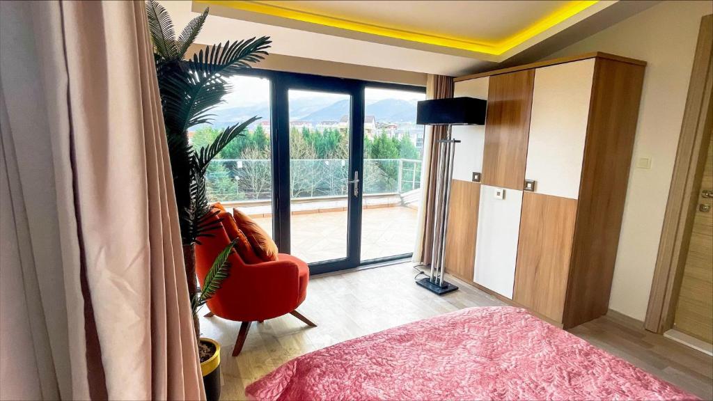 1 dormitorio con ventana grande y silla roja en Luxury Duplex With Wonderful View In Izmit, en Çavuşçiftliği
