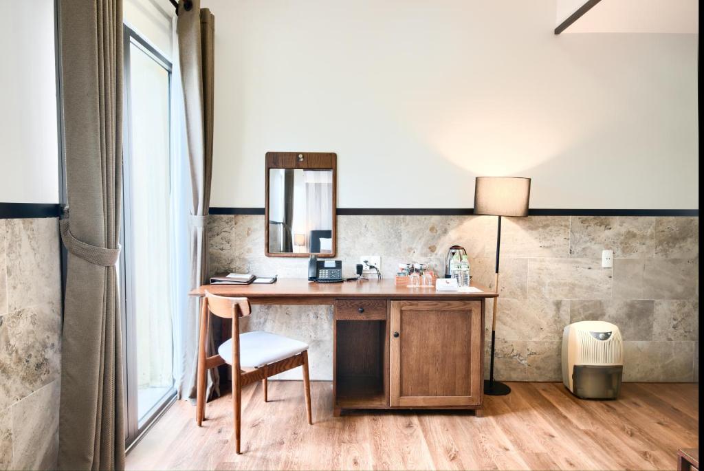 A compact in-room desk and drinks station beside a tall window.
