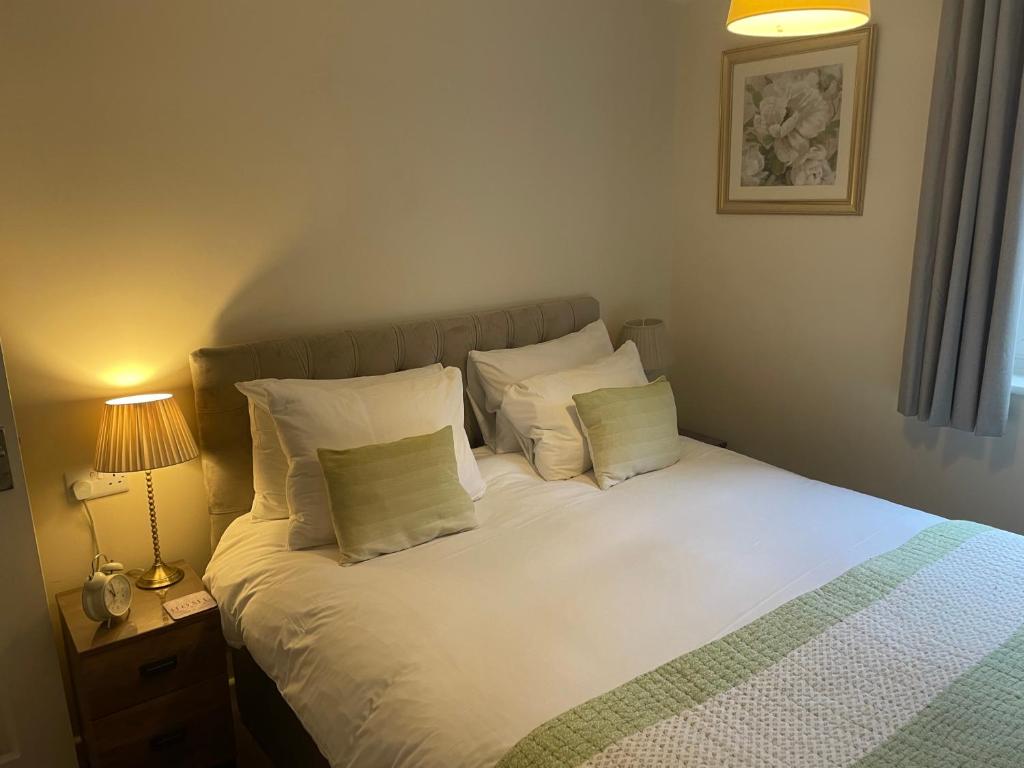 a bedroom with a bed with white sheets and pillows at Number 10 Serviced Apartment - Chapel in Southampton
