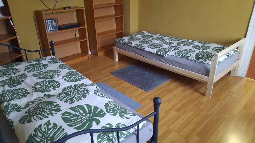 ein Schlafzimmer mit einem Bett mit einer grünen und weißen Decke in der Unterkunft FEWO2-1 Zim Apart-5 Bett-Küche-Dusche WC-Parkplatz in Berlin