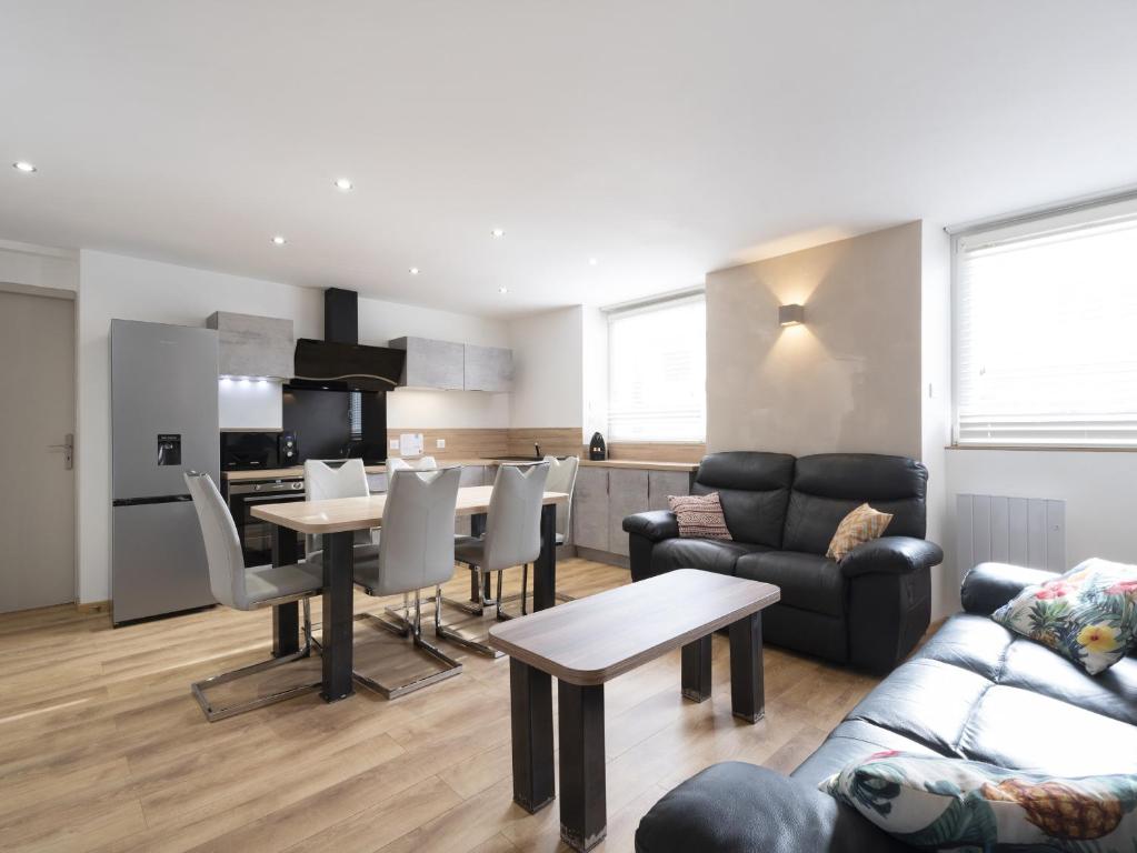 a living room with a table and a kitchen at Residence Louis Quartier Casino in Vittel