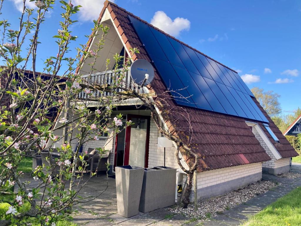 una casa con un solárium a un lado en De Druif 6 pers holiday home close to the National Park Lauwersmeer, en Anjum