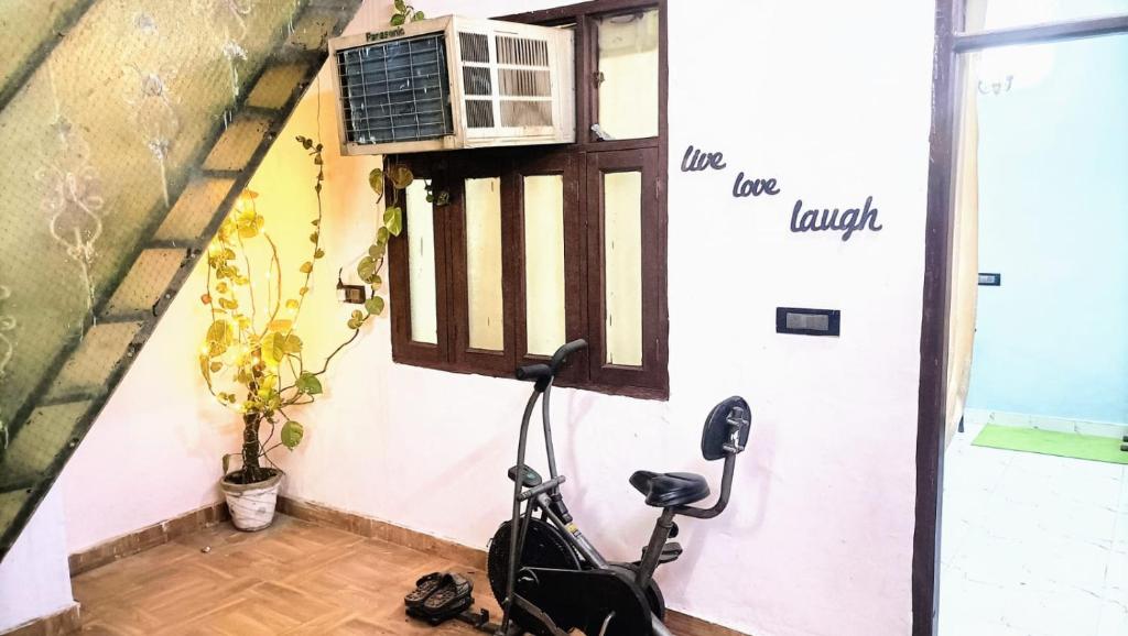a bike parked next to a wall with a window at Rooftop Floor with a big Room in New Delhi