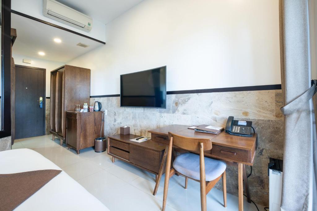 A compact in-room workspace beside the television and minibar cabinet.