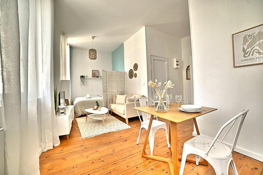 een eetkamer en een woonkamer met een tafel en stoelen bij Le Petit Vauban - Beach and center in Fouras