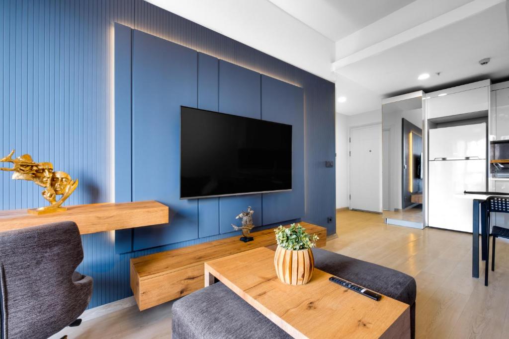 un salon avec un mur bleu dans l'établissement Modern Residence Near Mall of Istanbul and Metro, à Istanbul