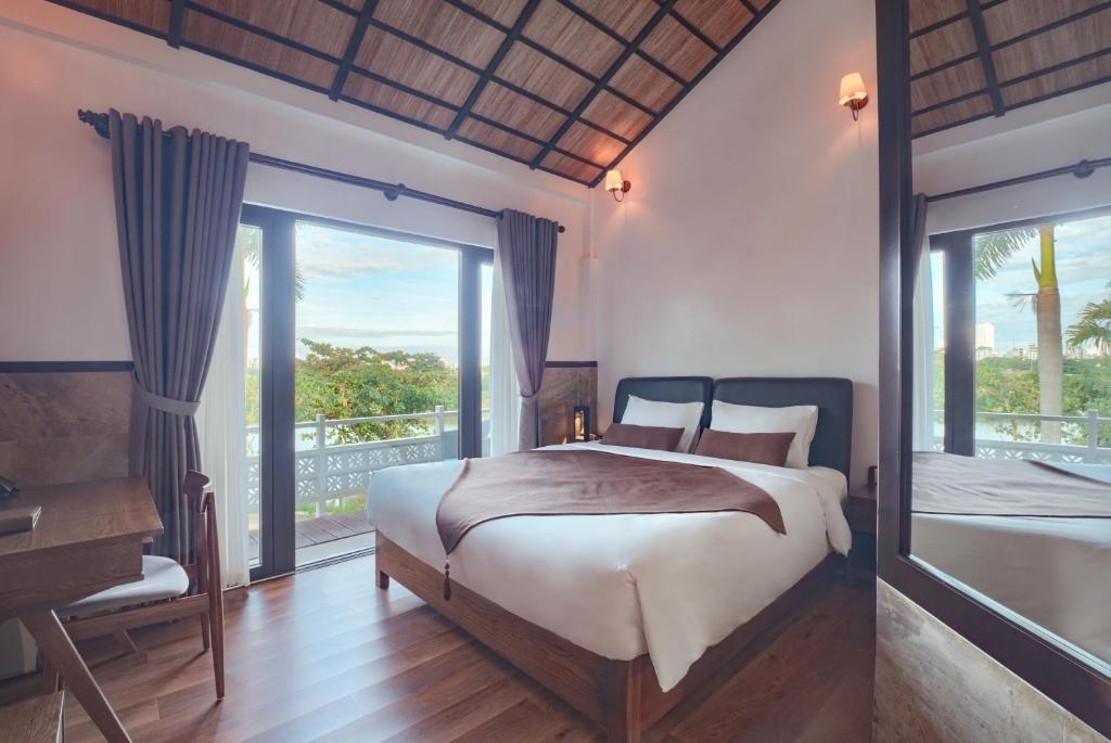 A timber-floored bedroom with a pitched woven ceiling and balcony doors.