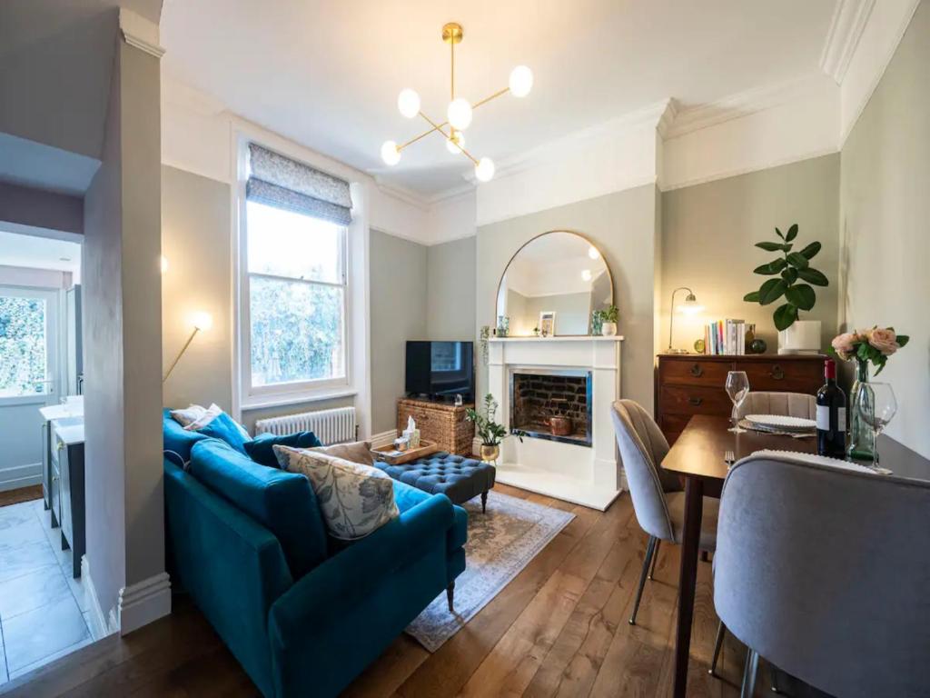 a living room with a blue couch and a table at Pass the Keys Boutique apartment 15 mins bus to Central London in London
