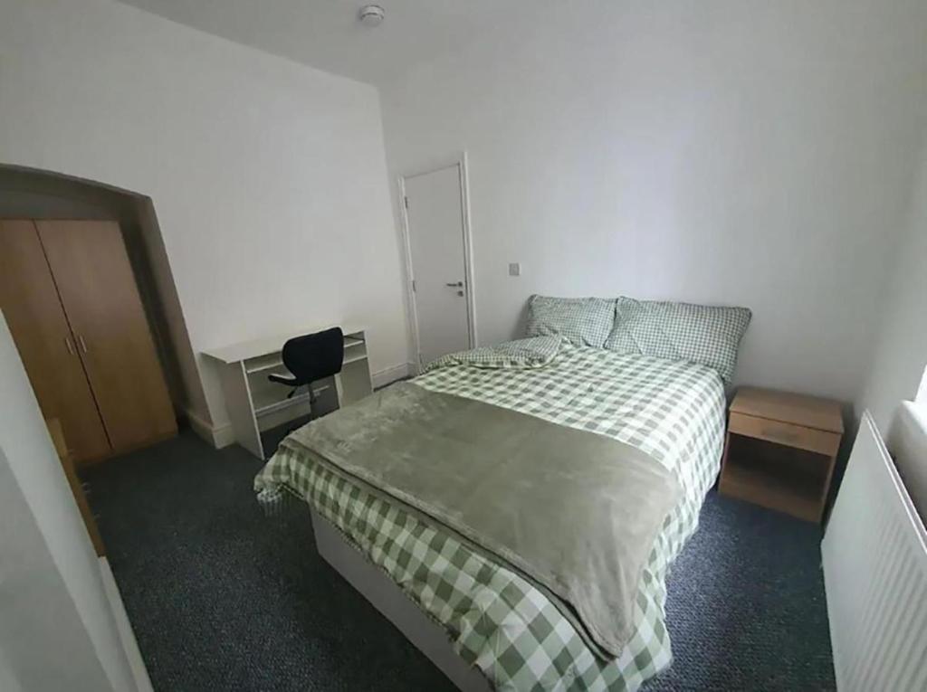 um quarto com uma cama, uma secretária e uma cadeira em Double-Bed L1 Burnley City Centre em Burnley