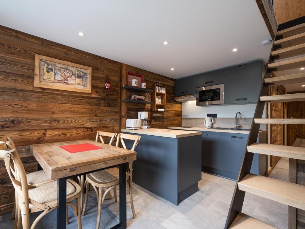 - une cuisine avec des murs en bois, une table et des chaises dans l'établissement Appartement Rénové, Calme avec Garage à 1.9 km du Village - 3***, 4 Personnes, WIFI, Proche Navettes - FR-1-304-235, à La Clusaz
