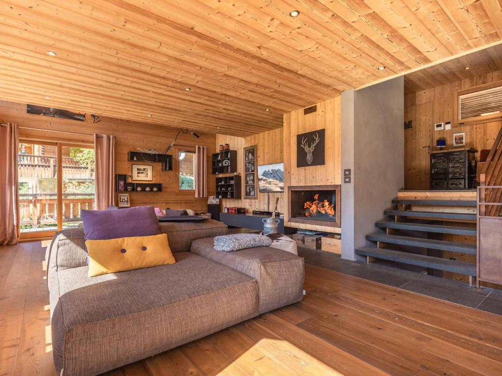 a living room with a couch and a fireplace at Chalet La Clusaz, 9 pièces, 13 personnes - FR-1-304-219 in La Clusaz