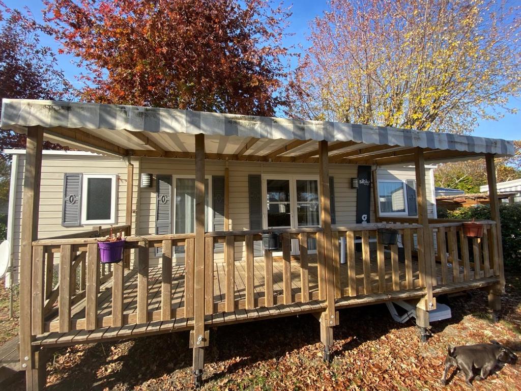 une petite maison avec un toit sur une terrasse couverte dans l'établissement MOBIL HOME 2 CHAMBRES CLIMATISE, à Gastes