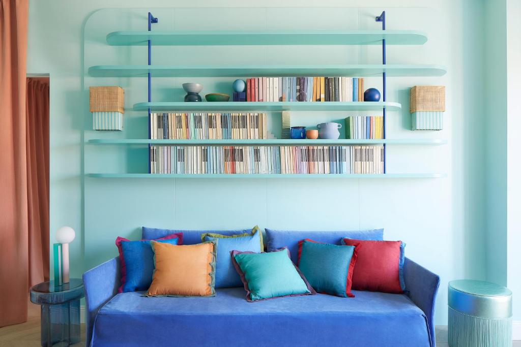 a blue couch with colorful pillows in a living room at Verde Acqua - Design & Comfort in Milan