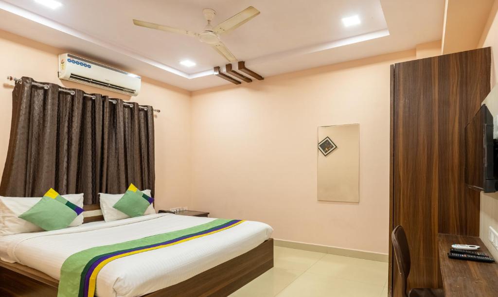 Treebo Trend Eco Stay T Nagar في تشيناي: غرفه فندقيه سرير وتلفزيون