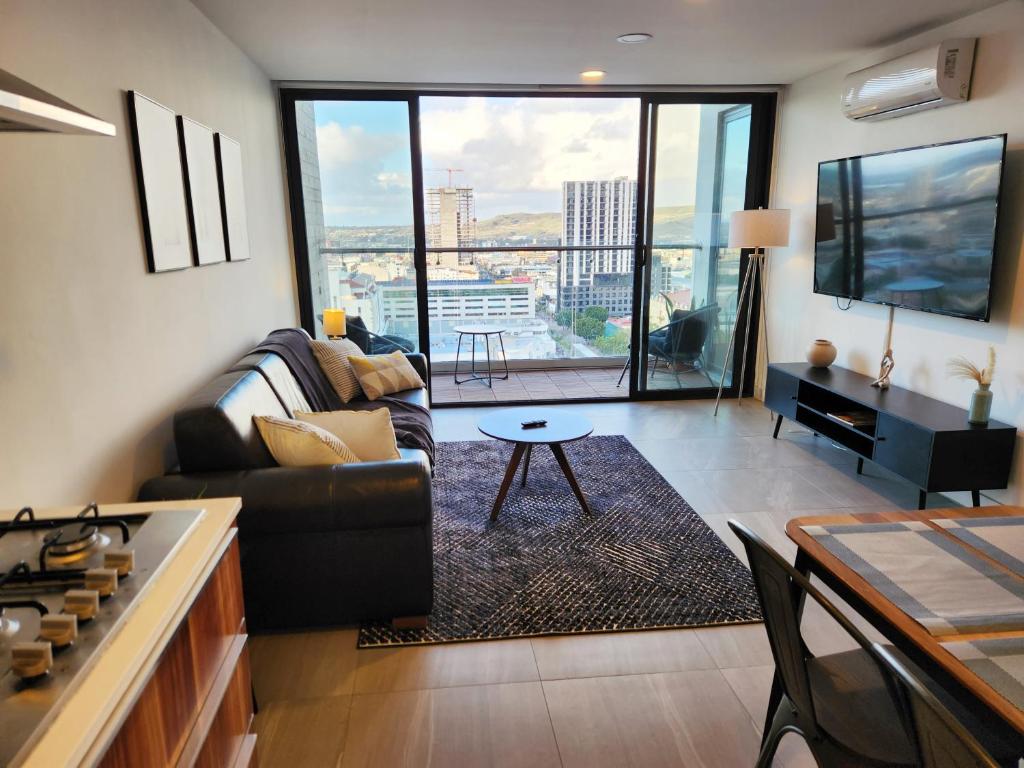 a living room with a couch and a table at Downtown Apartment with Balcony City View, Gym & Lounge in Tijuana