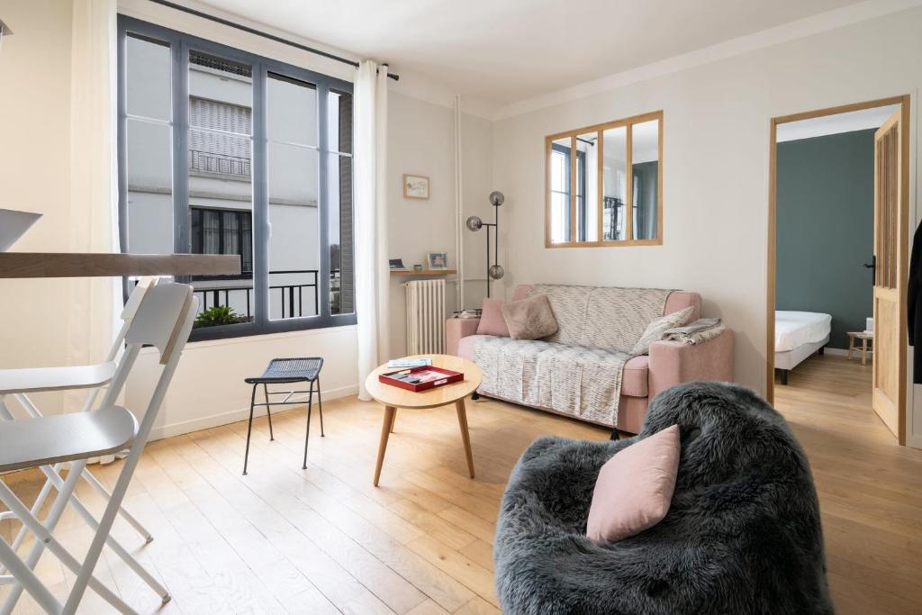 un salon avec un canapé et une table dans l'établissement Appartement Pompadour - Welkeys, à Boulogne-Billancourt