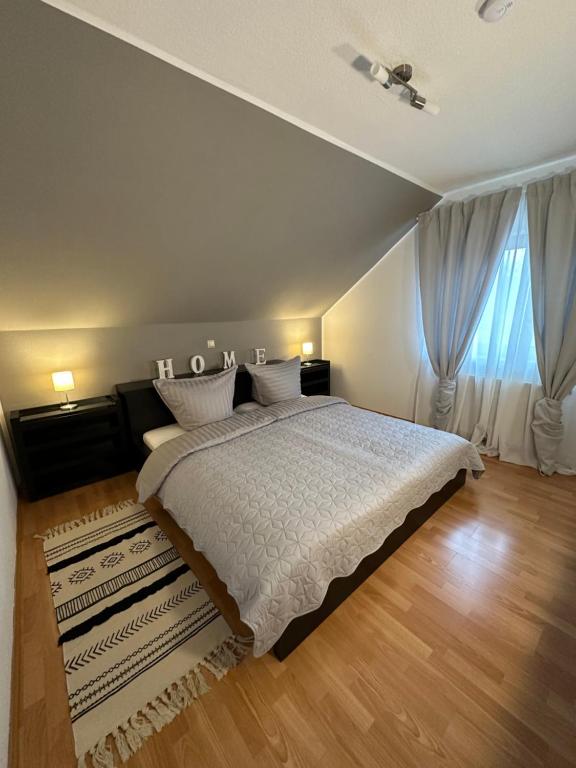 a bedroom with a large bed and a large window at Ferienwohnung Forest in Nonnweiler