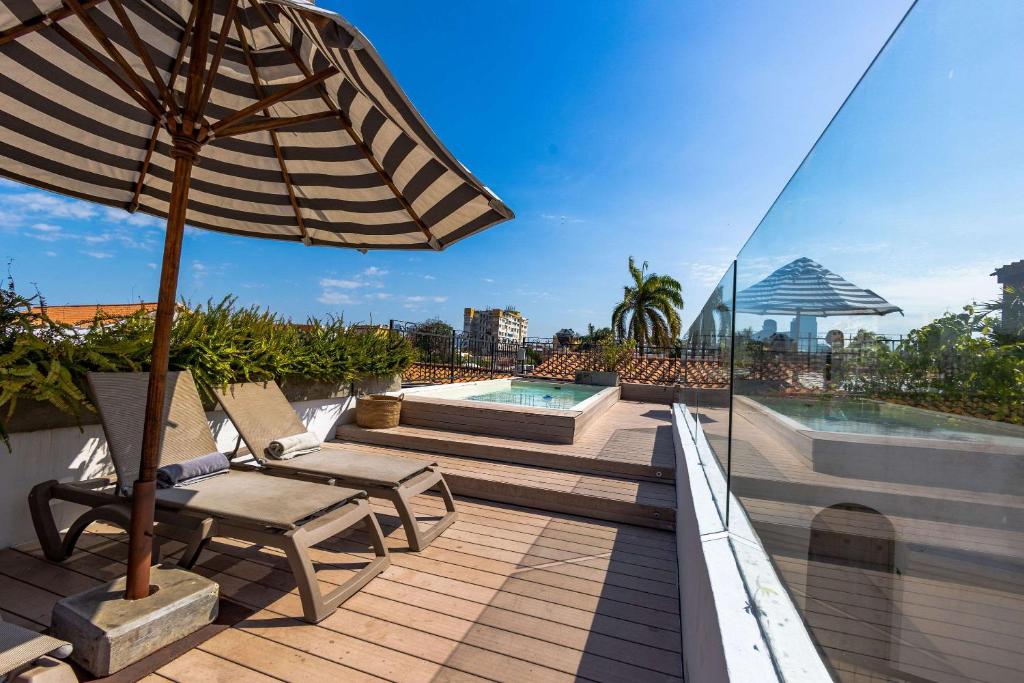a patio with an umbrella and chairs and a pool at Hotel Casa La Factoria by Faranda Boutique, a member of Radisson Individuals in Cartagena de Indias