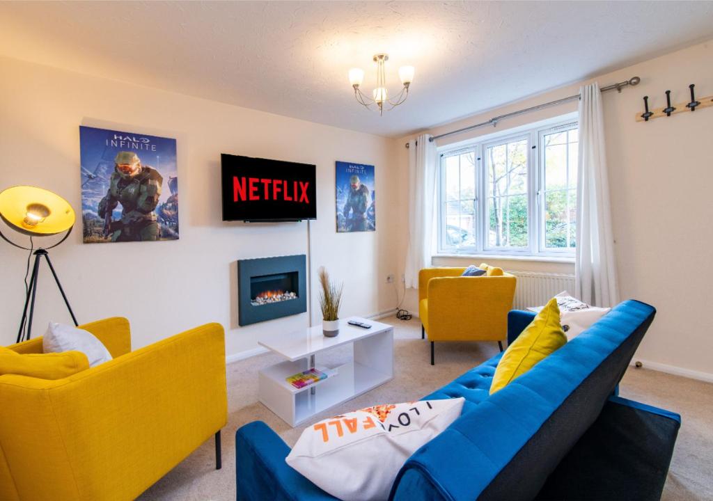 a living room with a blue couch and yellow chairs at Derby Mandarin 3 Bedroom Apartment with Garden and Parking in Derby