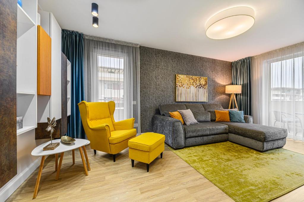 a living room with a couch and yellow chairs at ARA Apart Hotel #4 in Braşov