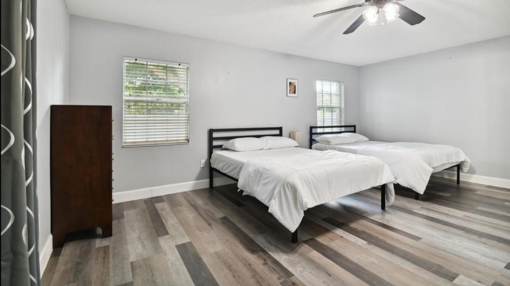 two beds in a room with a ceiling fan at Large Guest Rooms in Tampa in Tampa