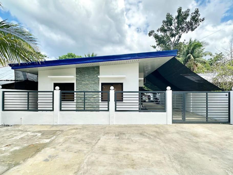 ein Haus mit einem blauen Dach und einem Zaun in der Unterkunft Apartment Unit Rental in Dauis Panglao Bohol in Dauis