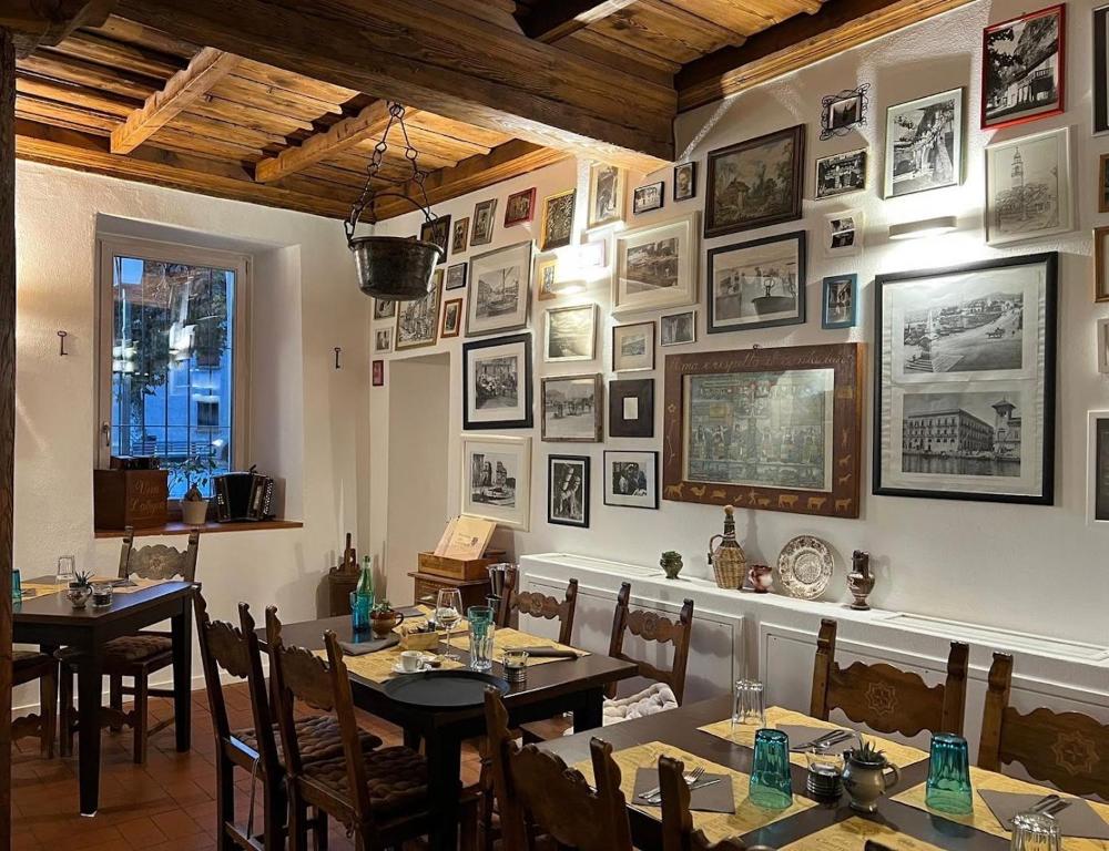 a dining room with tables and pictures on the wall at B&B ALLA PIAZZETTA DI TEGNA in Tegna