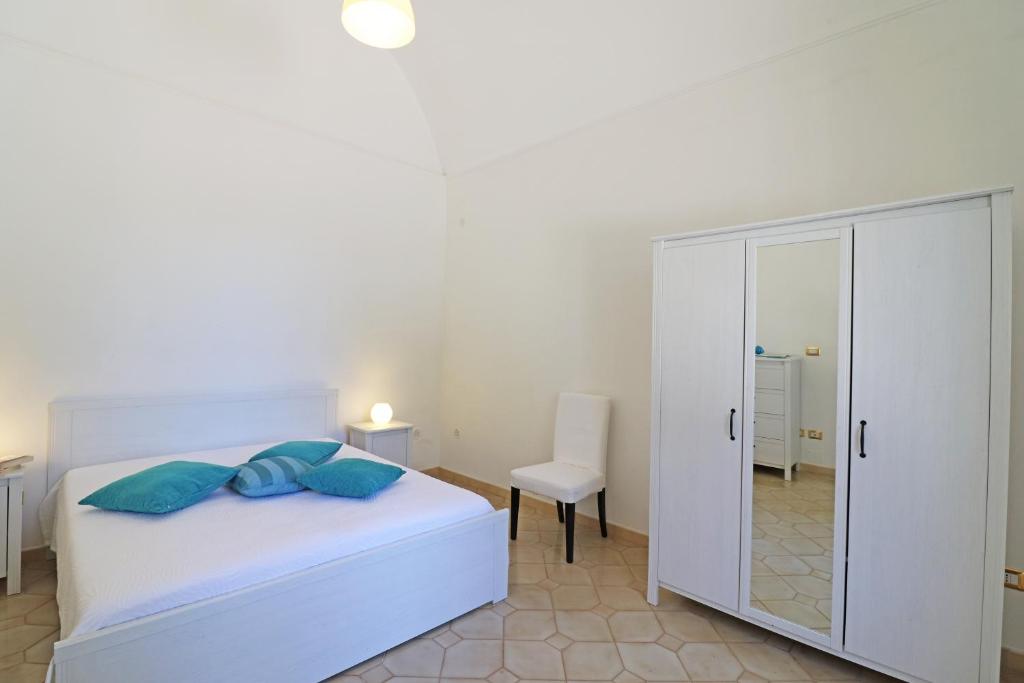 una camera con letto bianco e specchio di Villa on the Alimini Lakes a stones throw from the sea a Otranto