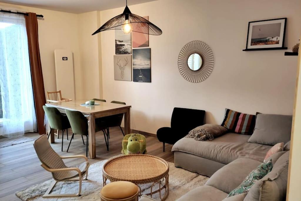 a living room with a couch and a table at Appartement T3 calme avec jardin privatif in Pontoise