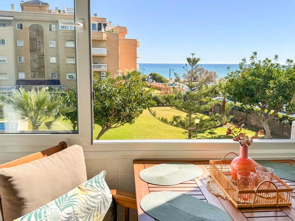 a room with a table and a view of the ocean at Apartamento con vistas al mar a 1 min de la playa in Málaga