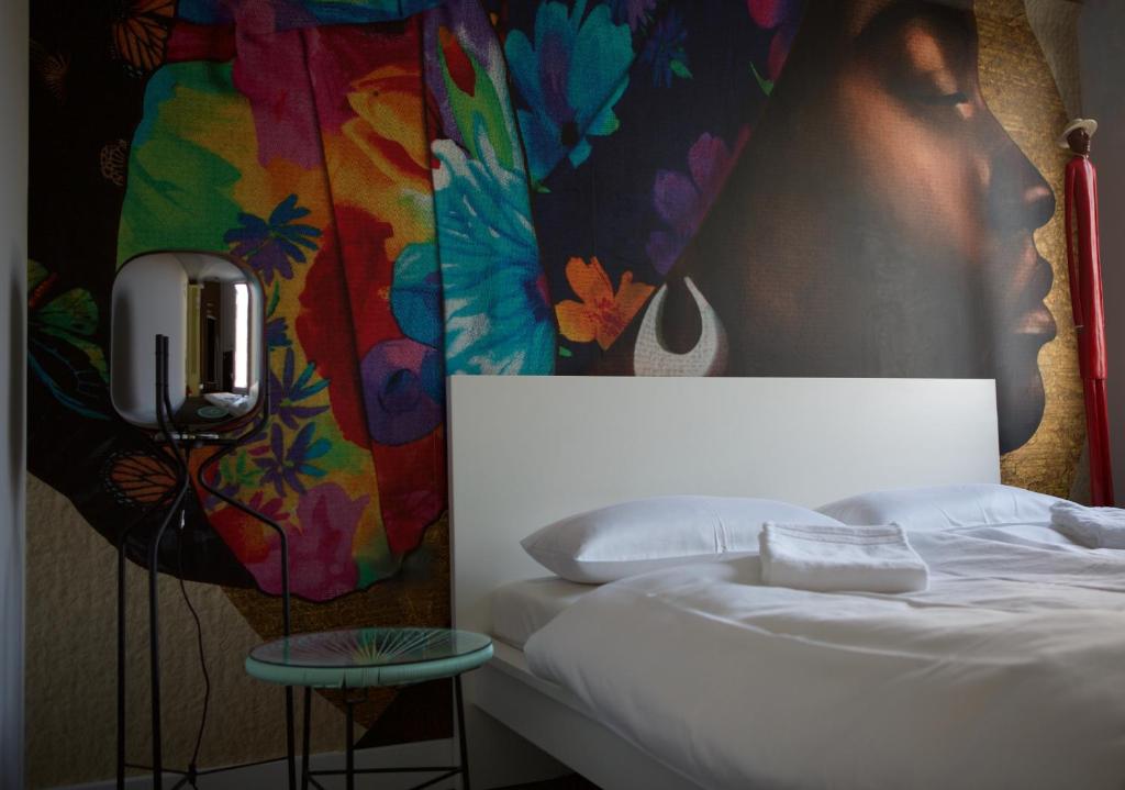 ein Schlafzimmer mit einem Bett und einem Wandgemälde in der Unterkunft @friends by CitySurfer in Hamburg