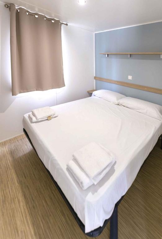 a bedroom with a white bed with towels on it at Holiday home in Calella de la Costa 3641 in Calella