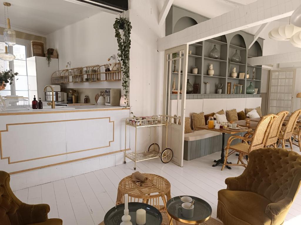 una sala con sedie e tavoli e una cucina di Maison Charmeilles - Gîte touristique - Coliving a Fronsac