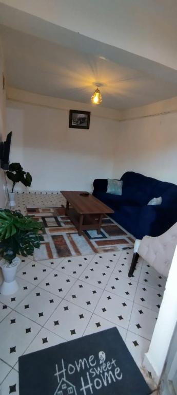 a living room with a blue couch and a table at Macha AIRBNB in Machakos