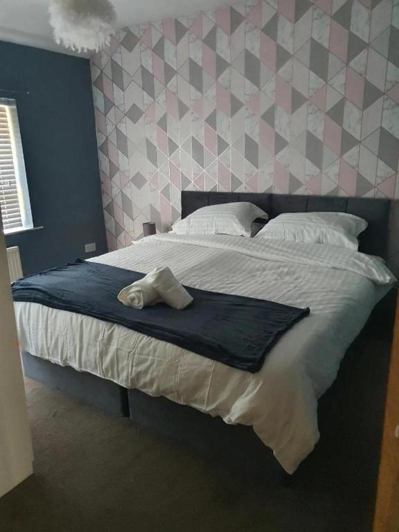 a bedroom with a large bed with a towel on it at Double Bedroom 96GLC Greater Manchester in Middleton