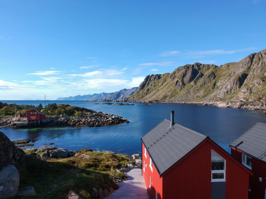 a red house on the shore of a body of water at Cabin in Lofoten with spectacular view in Ballstad