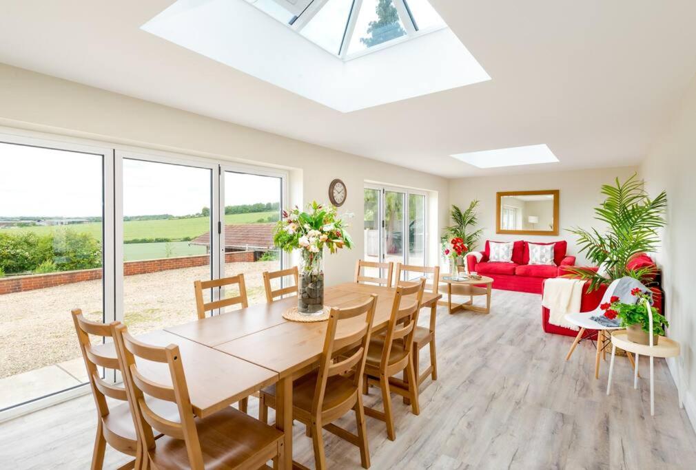 a dining room with a table and chairs and a couch at Croft House Sleeps 8 ꕤ Country Views nr Salisbury in Salisbury