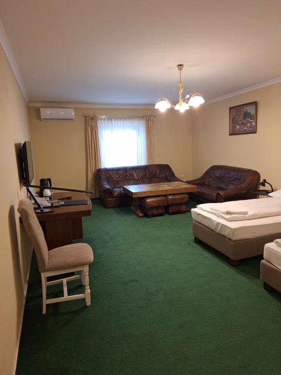 a living room with two beds and a couch at Hotel Malwa in Ostrów Wielkopolski