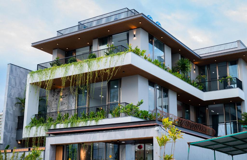 an apartment building with plants on the balconies at Peaceful Retreat Seafront Villa Da Nang in Da Nang