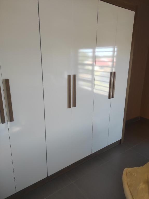 a white wardrobe with doors in a room at Brand new crane Apartments in Lenasia