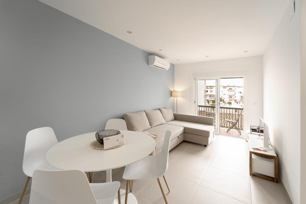 a white living room with a couch and a table at Apartamento WELCS EMP-109- al lado del canal in Empuriabrava