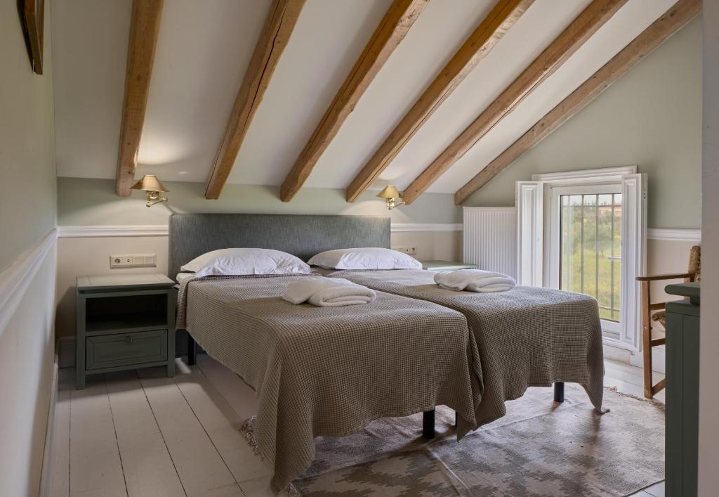 a bedroom with two beds with towels on them at Varaba Country House in Markopoulo