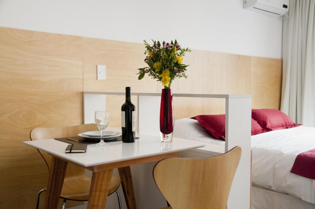 布宜諾斯艾利斯的住宿－巴勒莫2415號公寓，一张桌子,上面放着一瓶葡萄酒和花瓶