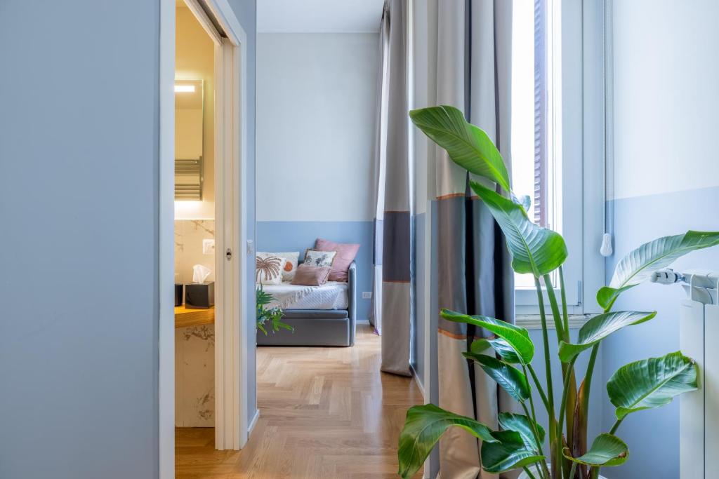 ein Wohnzimmer mit einem Sofa und einer Pflanze in der Unterkunft Suites Romae Rex in Rom