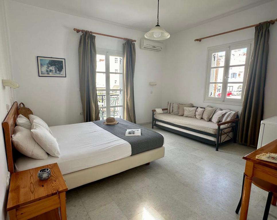 a bedroom with a bed and a couch in it at Ammosis Inn in Naxos Chora