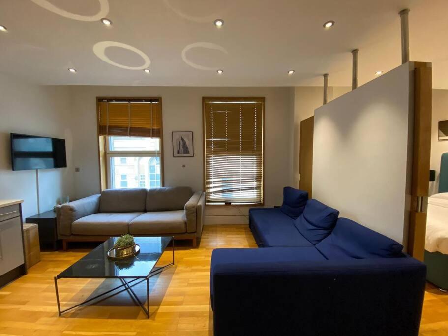 een woonkamer met een bank en een tafel bij Chic Living near Piccadilly HY11 in Londen