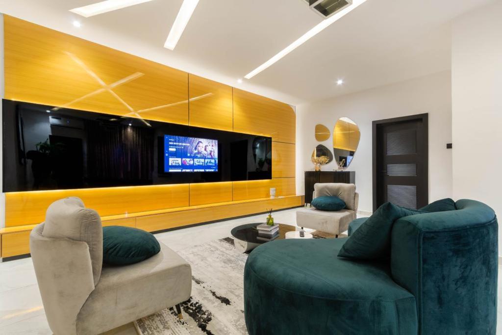 uma sala de estar com 2 cadeiras e uma televisão de ecrã plano em Chuzma Homes em Lagos